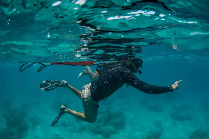 a man flying through the air while swimming in a body of water