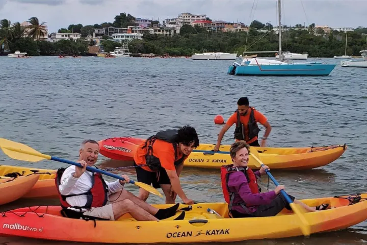 a group of people in a small boat in a body of water