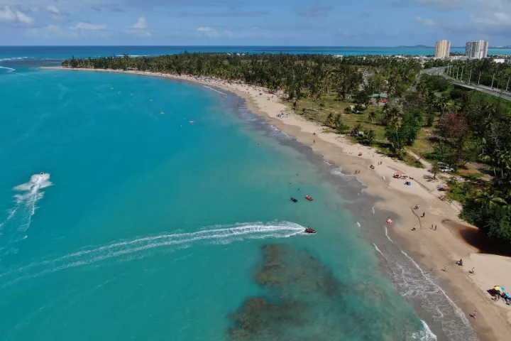 a group of people on a beach near a body of water