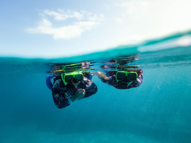 a man flying through the air while riding a wave in the ocean