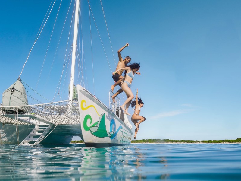 a man riding on the back of a boat in the water